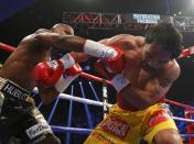 Manny Pacquiao of the Philippines takes a punch from Floyd Mayweather, Jr. of the U.S. in the second round during their welterweight WBO, WBC and WBA (Super) title fight in Las Vegas, Nevada, May 2, 2015. REUTERS/Steve Marcus