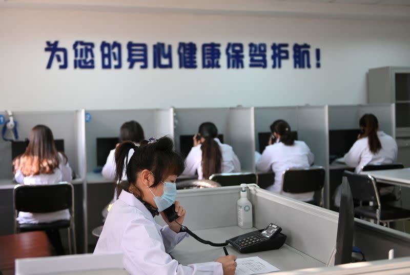 FILE PHOTO: Hotline operator for a free counselling service answers a phone while wearing a face mask, as the country is hit by an outbreak of the novel coronavirus, in Shenyang