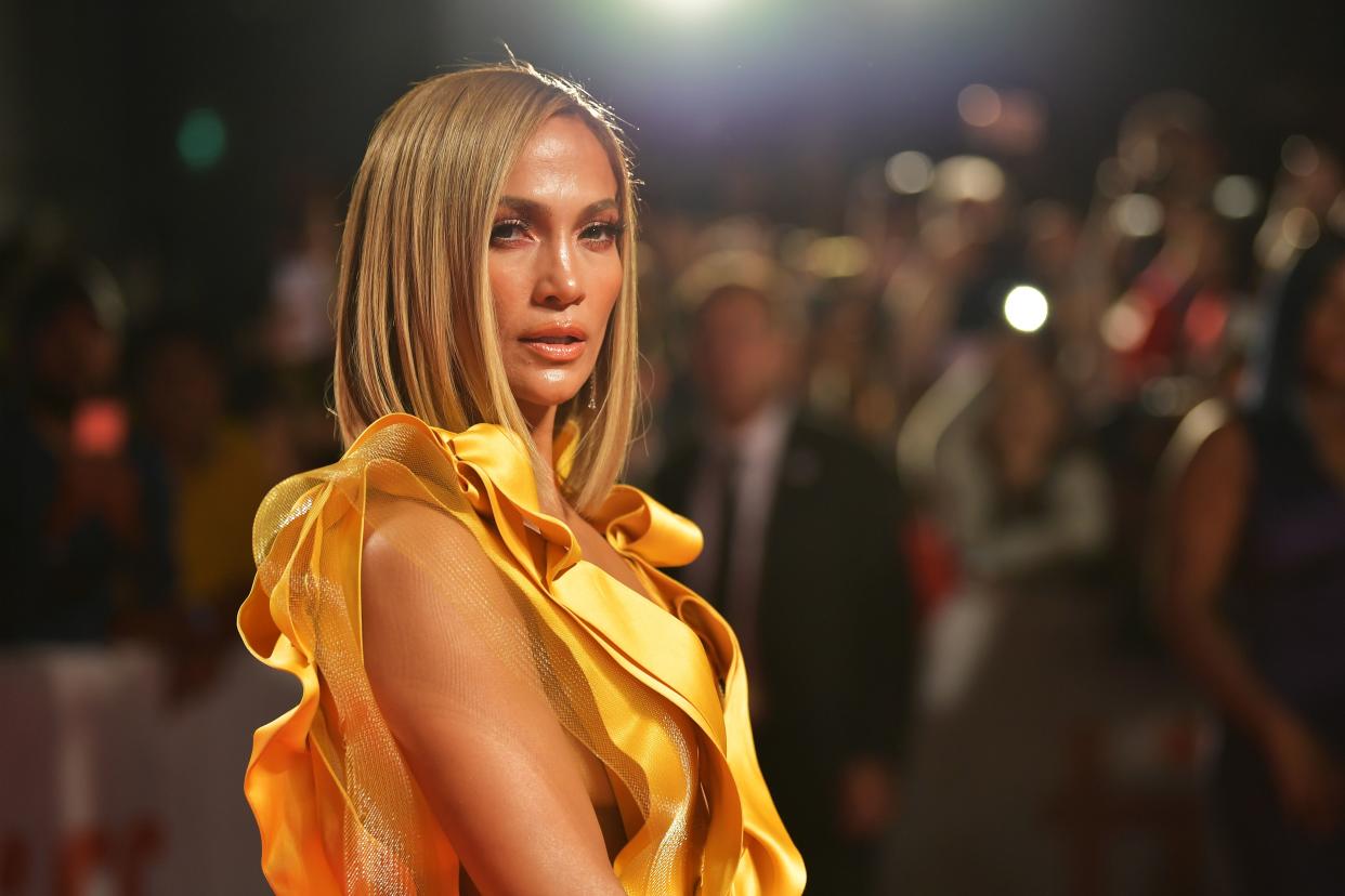Jennifer Lopez shows off her tanned skin in this lovely photo and she looks amazing in this yellow arm-less dress