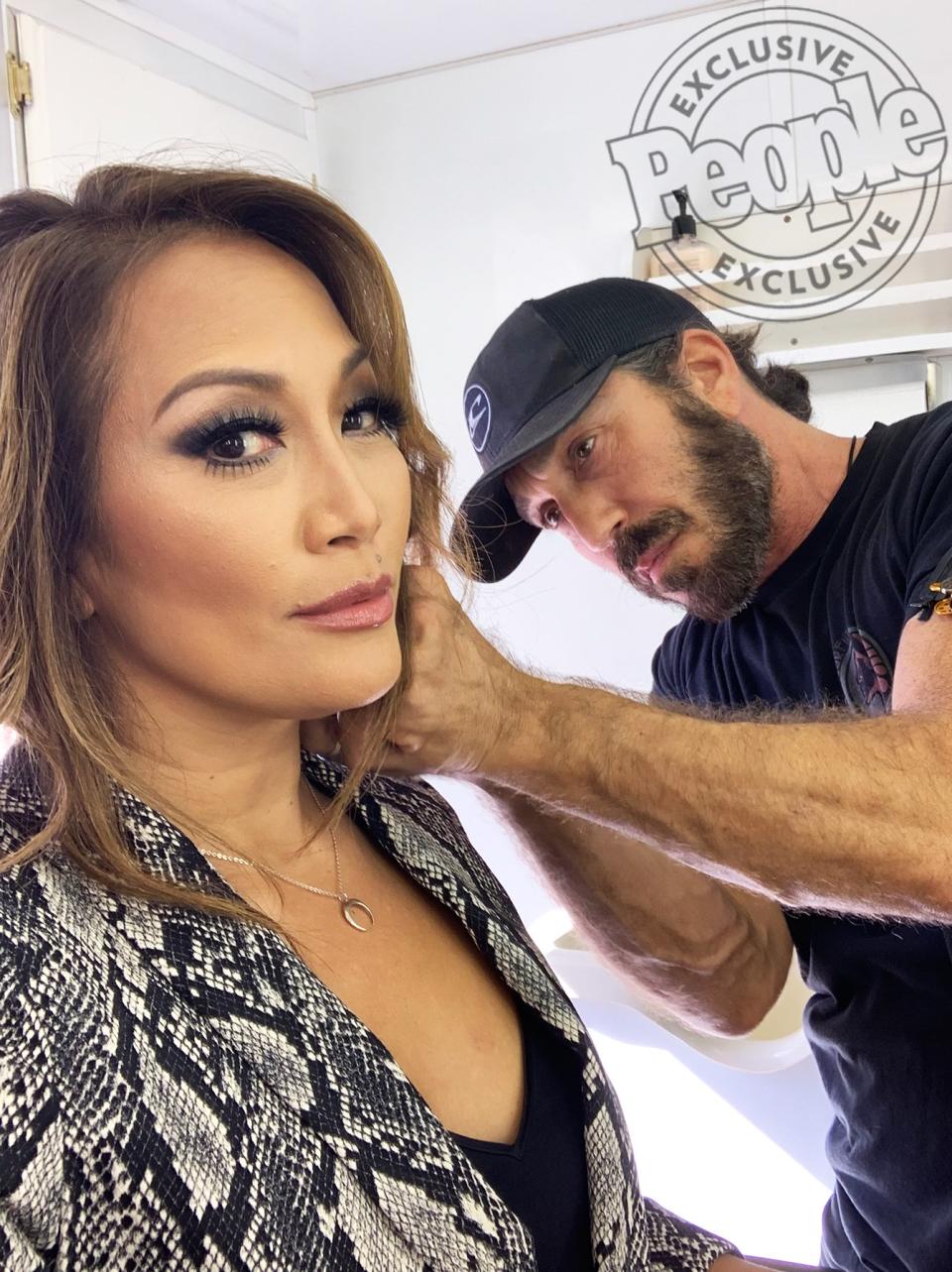 The <em>DWTS</em> judge rocked a classic smokey eye with a hint of gray sparkle. Her makeup artist, <a href="https://www.instagram.com/marylinmakeup/?hl=en" rel="nofollow noopener" target="_blank" data-ylk="slk:Marylin Lee Spiegel;elm:context_link;itc:0;sec:content-canvas" class="link ">Marylin Lee Spiegel</a>, tells PEOPLE she used the <a href="https://www.lisewatier.com/ca_en/24-hrs-glam-eyeshadow-midnight-glam" rel="nofollow noopener" target="_blank" data-ylk="slk:Lise Watier 24 Hrs Glam Eyeshadow Crayon in Midnight Glam;elm:context_link;itc:0;sec:content-canvas" class="link ">Lise Watier 24 Hrs Glam Eyeshadow Crayon in Midnight Glam</a> as an eye base because it “has great staying power.” She adds, “I defined her features with the <a href="https://click.linksynergy.com/deeplink?id=93xLBvPhAeE&mid=2417&murl=https%3A%2F%2Fwww.sephora.com%2Fproduct%2Fpro-sculpting-face-palette-P404776%3FskuId%3D1779792&u1=PEO%2CCarrieAnnInaba%27sDWTSPhotoDiary%3ASeeHowtheJudgeGetsReadyBehindtheScenes%2Channakateflanagan1%2CUnc%2CGal%2C7299401%2C201911%2CI" rel="nofollow noopener" target="_blank" data-ylk="slk:Mac Pro Face contour palette;elm:context_link;itc:0;sec:content-canvas" class="link ">Mac Pro Face contour palette</a> and created a full pout with <a href="https://thrivecausemetics.com/collections/lips/products/glossy-lip-hydrating-serum" rel="nofollow noopener" target="_blank" data-ylk="slk:Thrive Causemetics lip enhancer in Ruth;elm:context_link;itc:0;sec:content-canvas" class="link ">Thrive Causemetics lip enhancer in Ruth</a>, a gold flecked nude.”