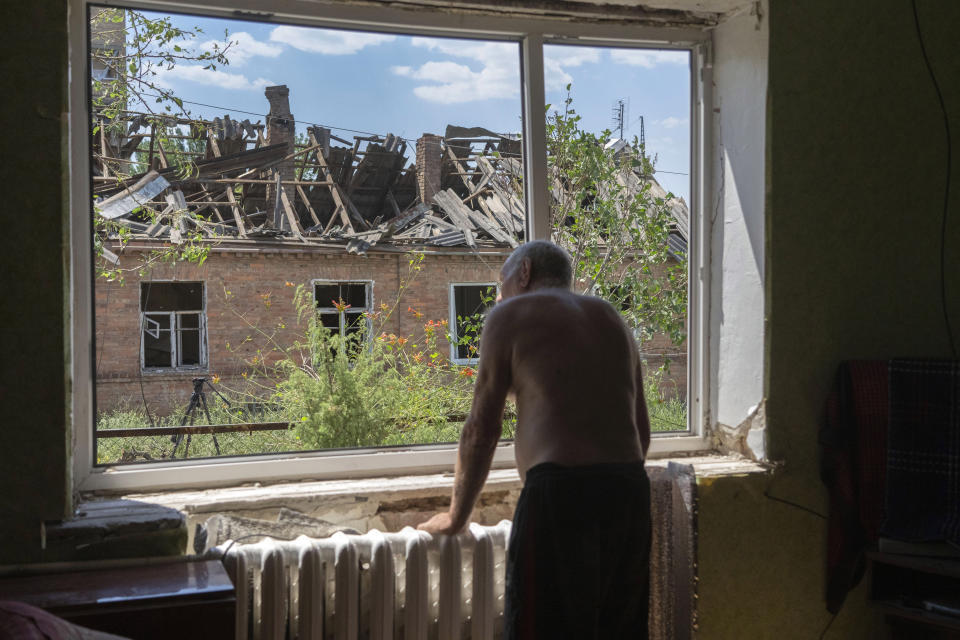 FILE - Victor Rosenberg, 81, looks out of a broken window in his home destroyed by the Russian rocket attack in the city centre of Bakhmut, Donetsk region, Ukraine, Friday, July 1, 2022. (AP Photo/Efrem Lukatsky, File)