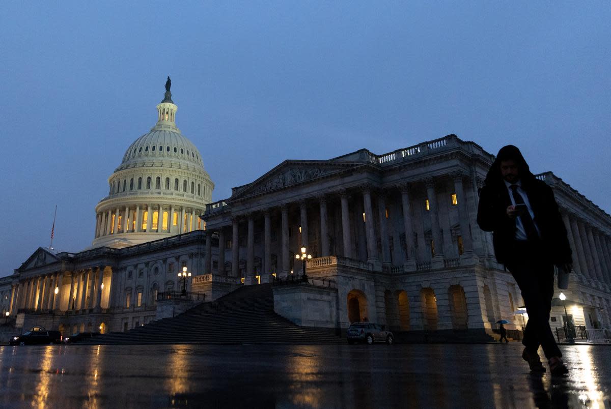 A person walks in front of the U.S. Capitol building at dusk, Wednesday, Jan. 25, 2022, in Washington, D.C. 