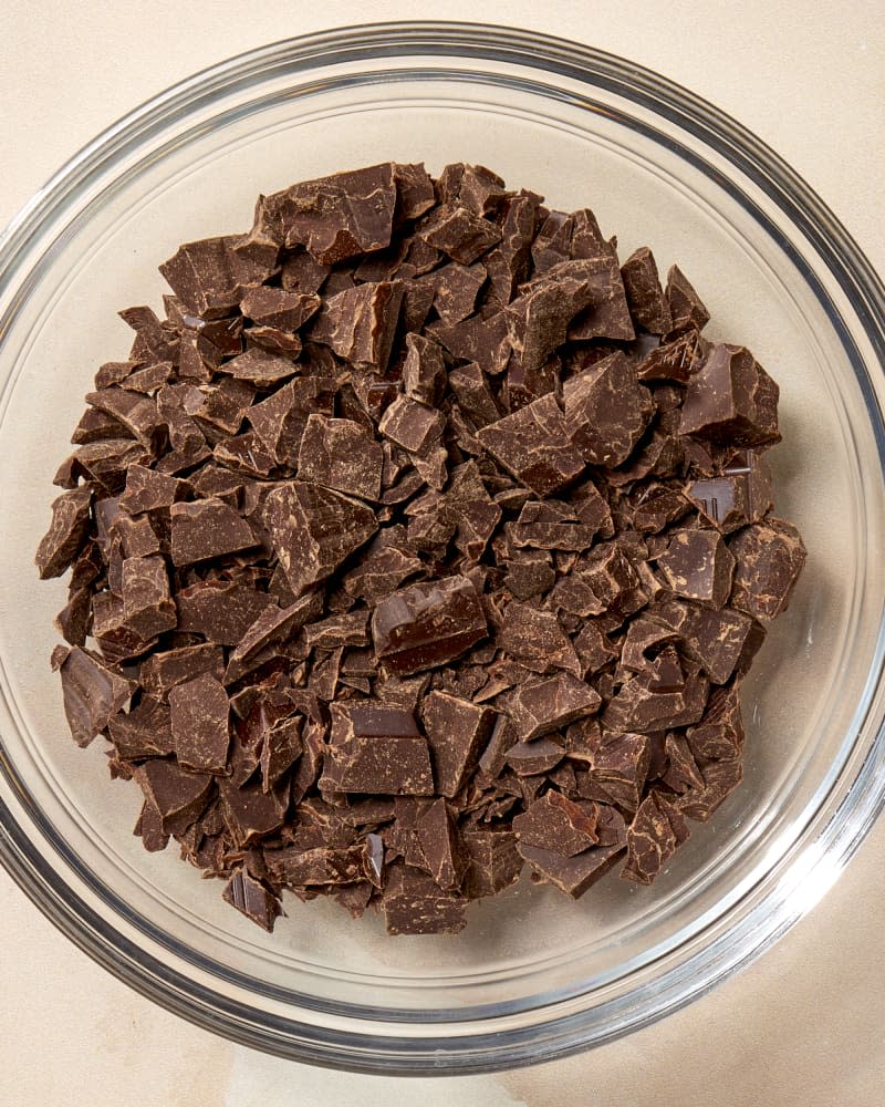 Overhead shot of chocolate chunks in a clear glass bowl.