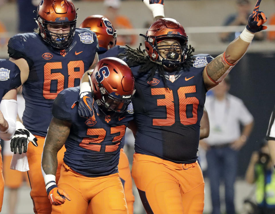 Syracuse fullback Chris Elmore (36) celebrates with running back Abdul Adams (23) after Adams scored a touchdown on a 3-yard run against West Virginia during the first half of the Camping World Bowl NCAA college football game Friday, Dec. 28, 2018, in Orlando, Fla. (AP Photo/John Raoux)