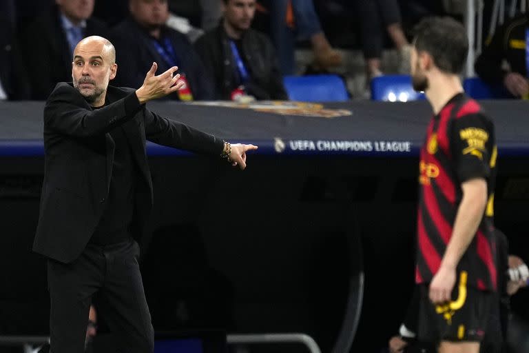 Pep Guardiola, con el banco de suplentes, detrás, sin movimiento