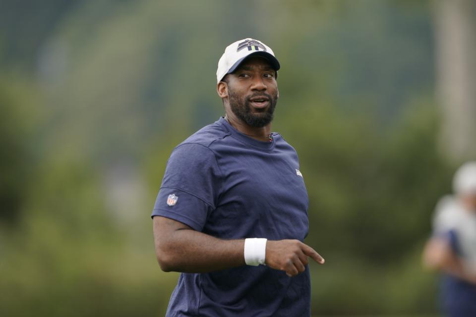 FILE - Aaron Curry, the Seattle Seahawks defensive assistant and linebackers coach, walks on the field during NFL football practice, Thursday, Aug. 19, 2021, in Renton, Wash. Once considered a bust as a player, Curry reinvented his football life and in the process found himself back in the NFL and on a path that he hopes someday will reach the position of head coach. (AP Photo/Ted S. Warren, File)