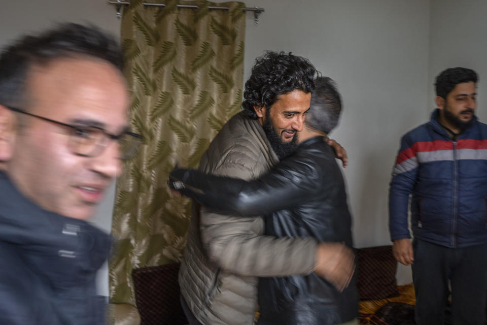 Fahad Shah, founder and editor of news portal The Kashmir Walla, left, huga a colleague at his residence on the outskirts of Srinagar, Indian controlled Kashmir, Friday, Nov. 24, 2023. Indian authorities have released the prominent Kashmir journalist on bail nearly two years after he was arrested on accusations of publishing “anti-national content” and “glorifying terrorism.” (AP Photo/Dar Yasin)