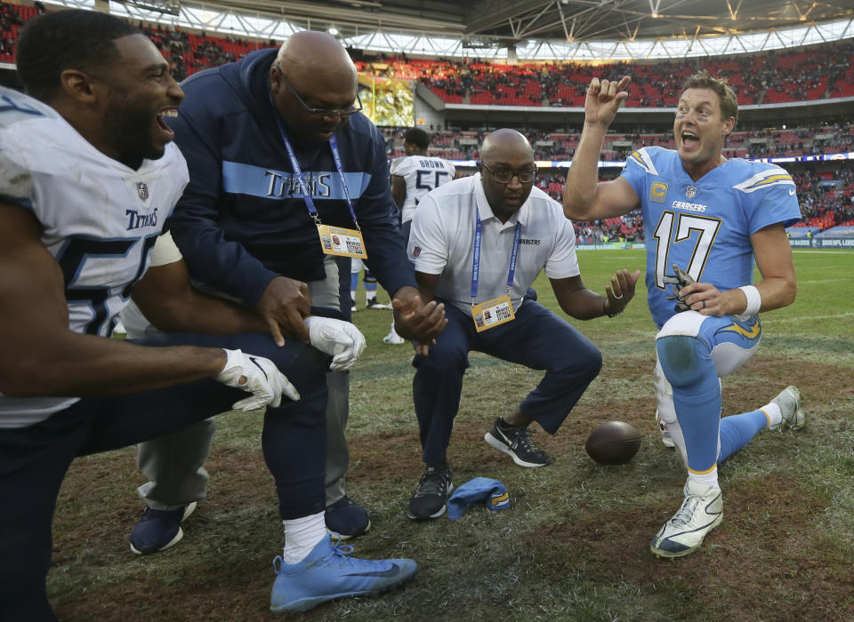 Los Angeles Chargers quarterback Philip Rivers (17), right, gestures as he prepares to join other players and coaches in prayer after an NFL football game against Tennessee Titans at Wembley stadium in London, Sunday, Oct. 21, 2018. Los Angeles Chargers won the match 20-19. (AP Photo/Tim Ireland)