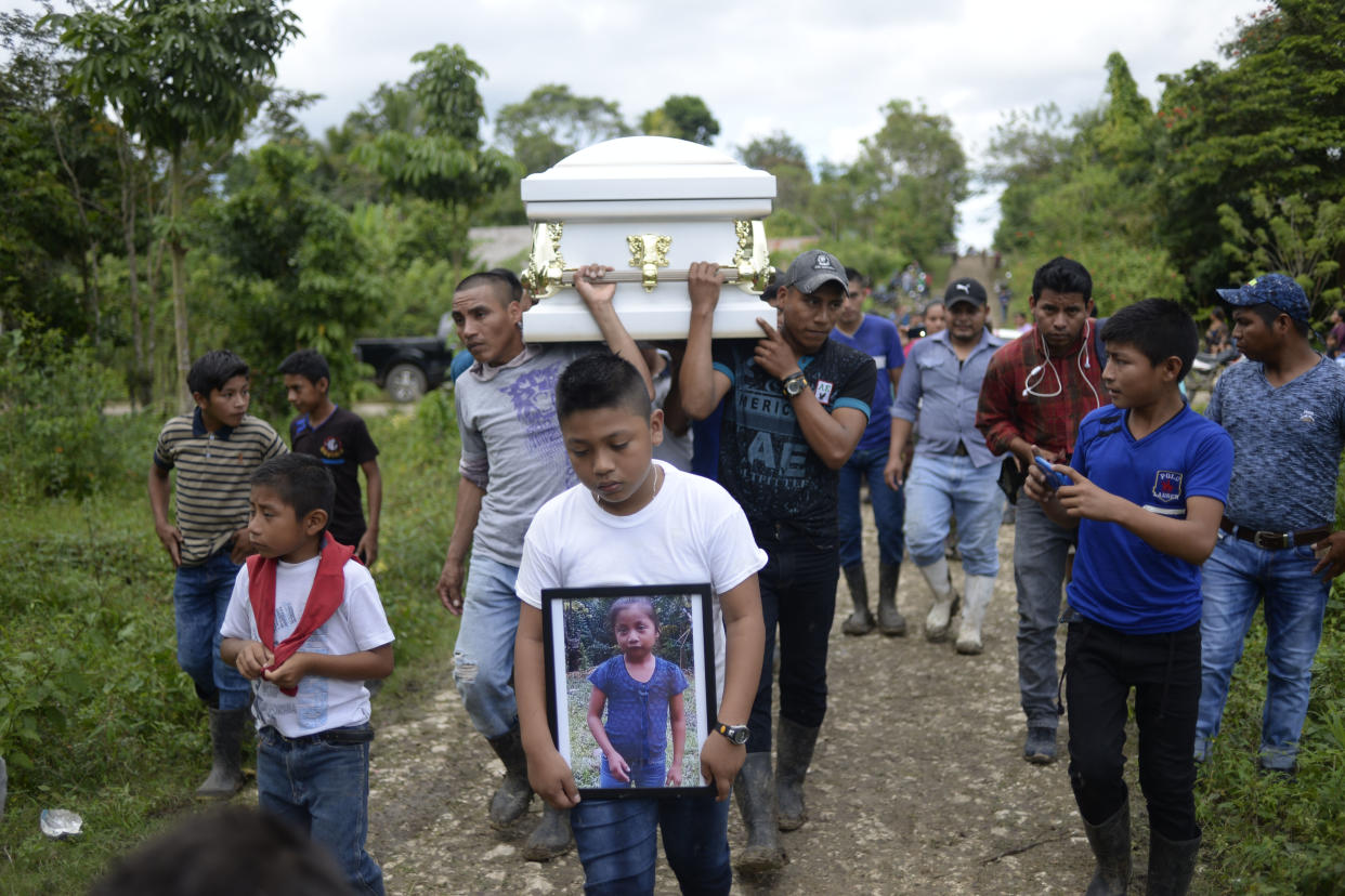 A boy carries a photo of Guatemalan 7-year-old Jakelin Caal Maquin, who died two days after being taken into custody by the U.S. Border Patrol, as her coffin is carried to the cemetery on Dec. 25, 2018. (Photo: Johan Ordonez/AFP/Getty Images)