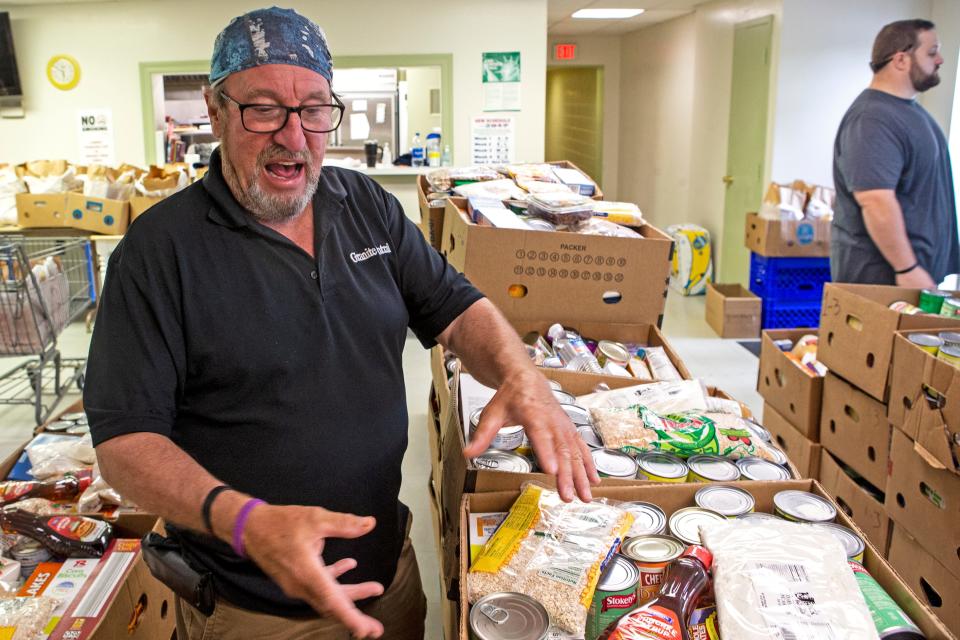 Volunteers Gene Laskoswki, left, prepares boxes for Eric to place on the conveyor belt at the  Greenbank Church of Christ drive-thru food pantry in Prices Corner on Thursday, Aug. 25, 2022. The pantry serves free meals to the community and continues to follow COVID-19 protocols.