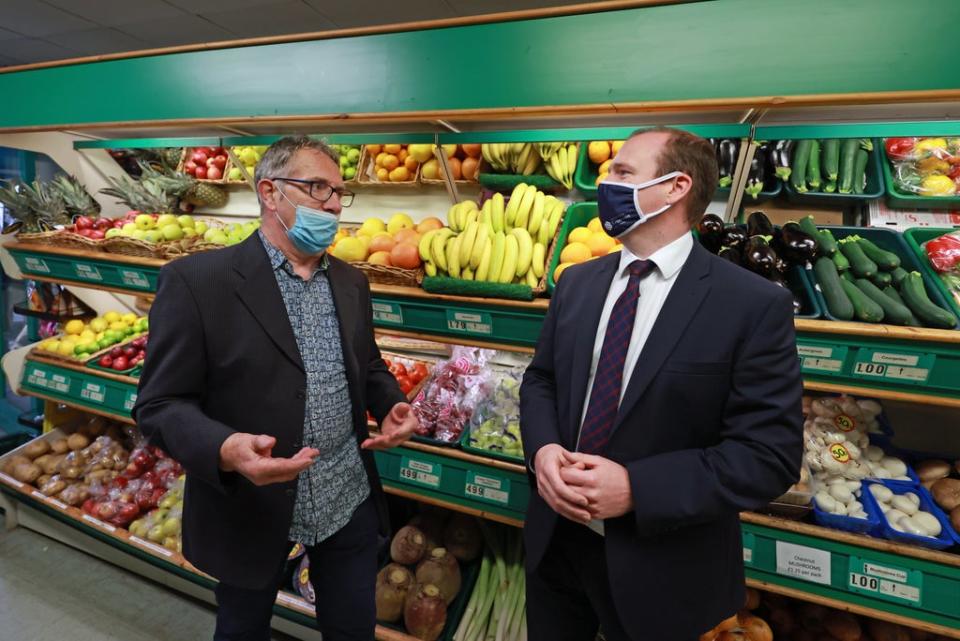 Economy Minister Gordon Lyons (right) speaks to Michael Goggin, owner of Michel’s fruit and vegetable shop on the Ormeau Road in Belfast (Liam McBurney/PA) (PA Wire)