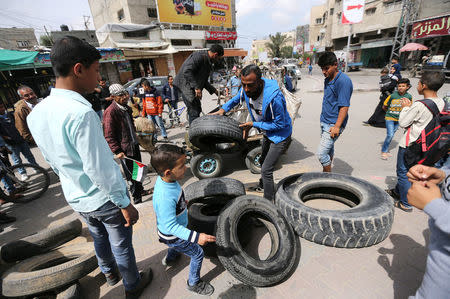 Palestinian activists collect tyres to be burnt along Israel-Gaza border, in the southern Gaza Strip April 3, 2018. REUTERS/Ibraheem Abu Mustafa