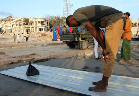 A Somali volunteer prays at the scene of last Saturday explosion in KM4 street in the Hodan district in Mogadishu, Somalia October 17, 2017. REUTERS/Feisal Omar