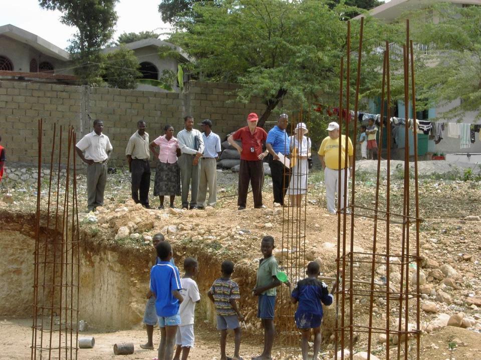 Don Miller, pictured in red, stood at a new church construction in Haiti during one of his mission trips in this undated photo.