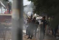 Police officers fire tear gas and a water cannon during clashes with protesters supporting the opposition Cambodia National Rescue Party (CNRP), near the Royal Palace in central Phnom Penh September 15, 2013. (REUTERS/Samrang Pring)