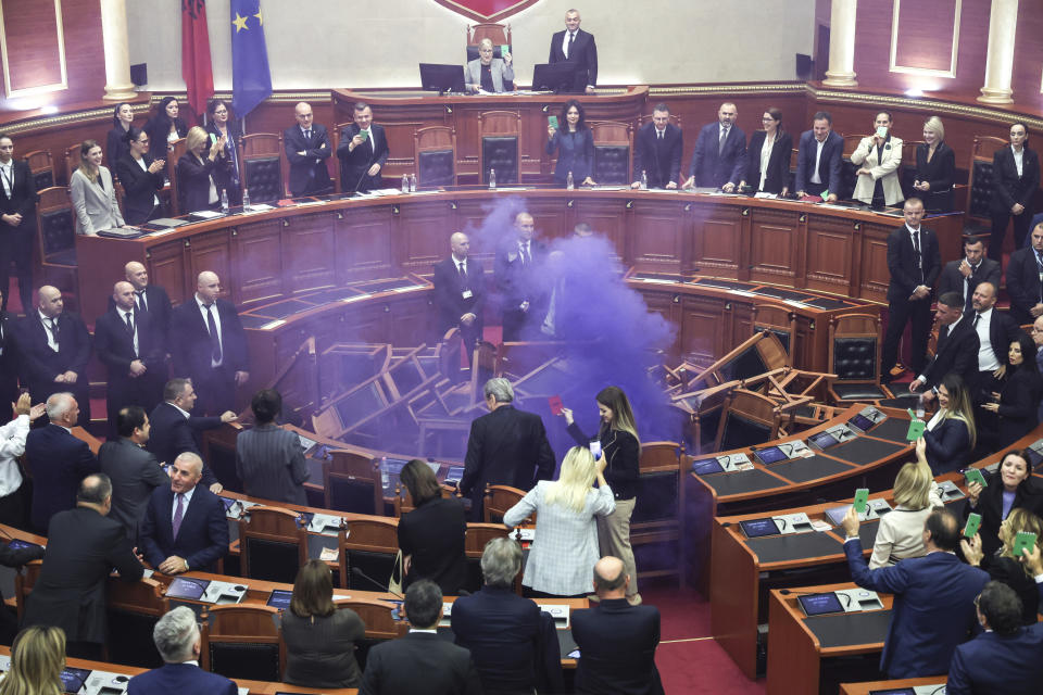 A coloured smoke bomb lighten by Ervin Salianji an opposition lawmaker is seen during a parliament session in Tirana, Albania, Thursday, Nov. 2, 2023. Albanian opposition has tried to disrupt the parliamentary session in protest to what they called the authoritarian rule from the governing Socialist party. (AP Photo)