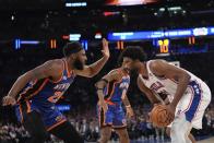 New York Knicks' Mitchell Robinson, left, defends Philadelphia 76ers' Joel Embiid, right, during the first half of Game 5 in an NBA basketball first-round playoff series, Tuesday, April 30, 2024, in New York. (AP Photo/Frank Franklin II)