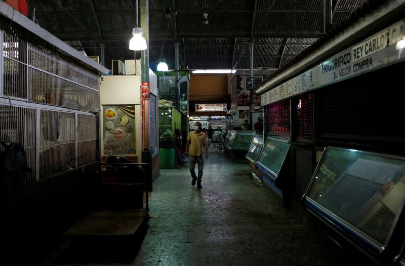 A person wearing a protective mask in a market after the start of quarantine in response to the spread of coronavirus disease (COVID-19) in Caracas