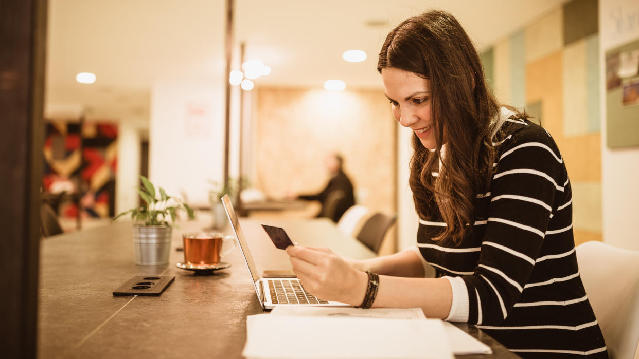 Pregnant businesswoman on coffee break making online credit card purchase.