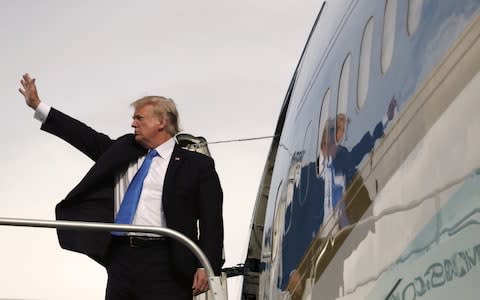 U.S. President Donald Trump waves goodbye as he enters Air Force One after participating in the East Asia Summit - Credit: Andrew Harnik 