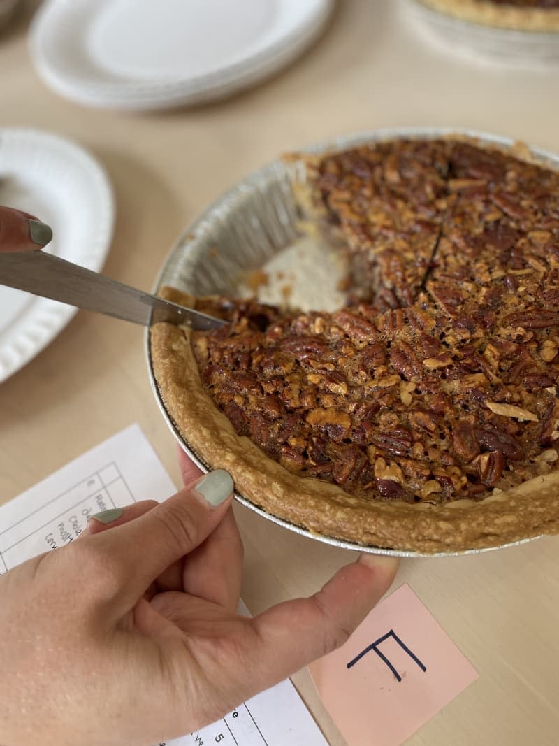 pecan pies in silver pie tins with pieces taken out