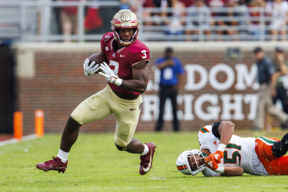Florida State running back Trey Benson (3) runs by Miami's Francisco Mauigoa (51) during the first half of an NCAA college football game, Saturday, Nov. 11, 2023, in Tallahassee, Fla. (AP Photo/Colin Hackley)