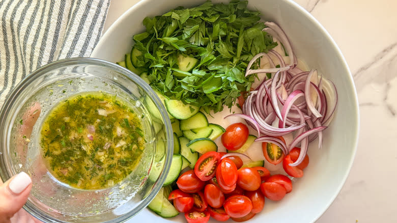 adding dressing to salad