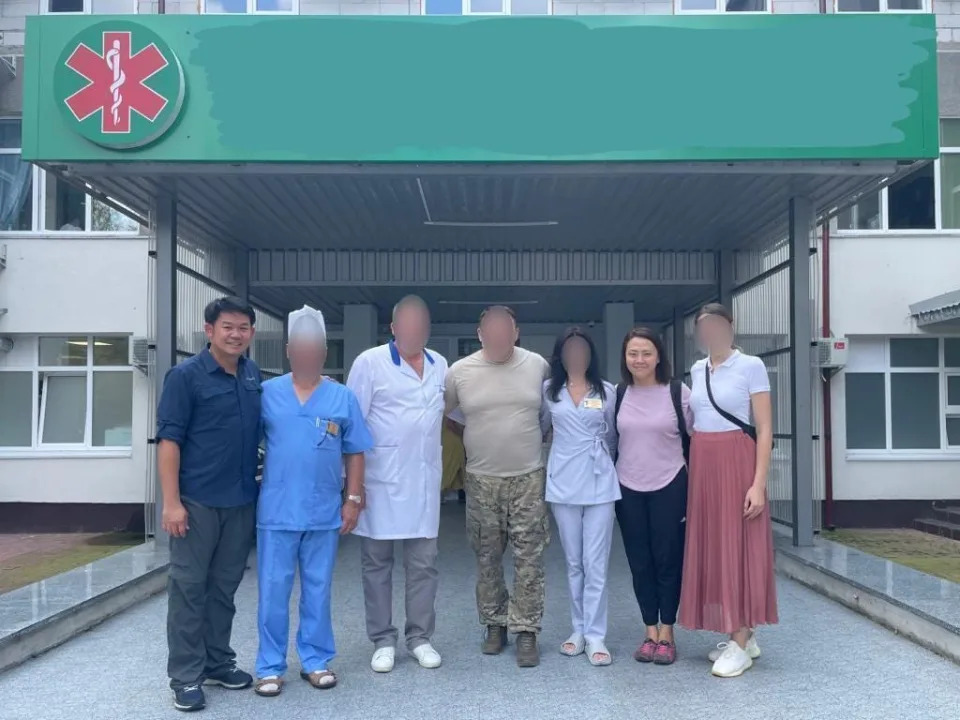 Lam and Taslim pose for a photo with doctors and directors at a hospital in Ukraine after delivering medical equipment.