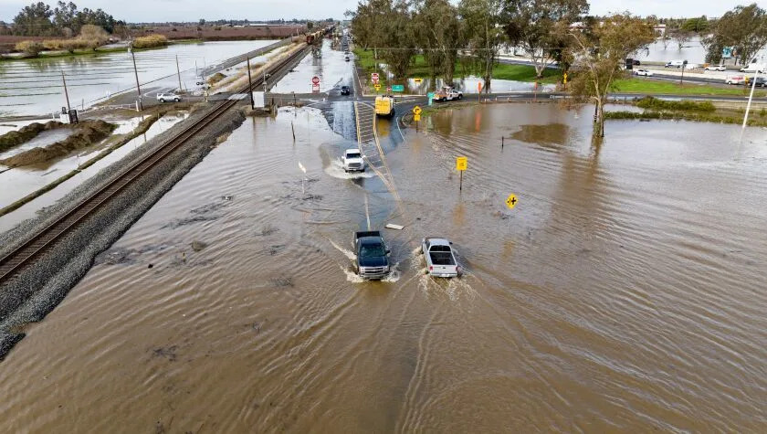 This aerial view shows vehicles driving on a flooded road in Merced, California on January 10, 2023. - A massive storm called a bomb cyclone&quot; by meteorologists has arrived and is expected to cause widespread flooding throughout the state. (Photo by JOSH EDELSON / AFP) (Photo by JOSH EDELSON/AFP via Getty Images)