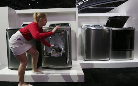 An exhibitor demonstrating an Inverter Direct Drive washing machine at the LG exhibit during the 2016 Consumer Electronics Show in Las Vegas - Credit:  DAVID MCNEW/ AFP