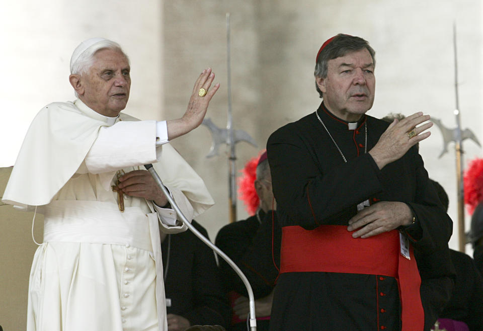 FILE - In this Oct. 12, 2005, file photo, then Pope Benedict XVI, left, and Cardinal George Pell bless the faithful during the weekly general audience in St. Peter's square at the Vatican. Cardinal George Pell was sentenced in an Australian court on Wednesday, March 13, 2019 to 6 years in prison for molesting two choirboys in a Melbourne cathedral more than 20 years ago. (AP Photo/Gregorio Borgia, File)