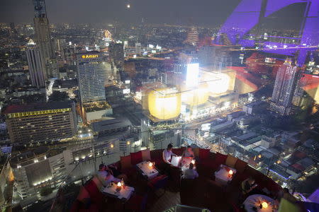 Visitors and tourists enjoy drinks and the view from a rooftop bar in central Bangkok in this April 1, 2015 file photo. REUTERS/Damir Sagolj/Files