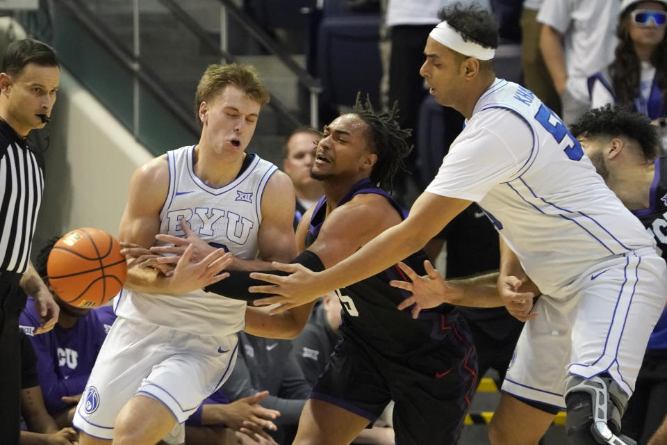 BYU guard Dallin Hall, left, has the ball knocked away by TCU forward Chuck O'Bannon Jr., center, as BYU center Aly Khalifa, right, looks on during the first half of an NCAA college basketball game Saturday, March 2, 2024, in Provo, Utah. (AP Photo/George Frey)