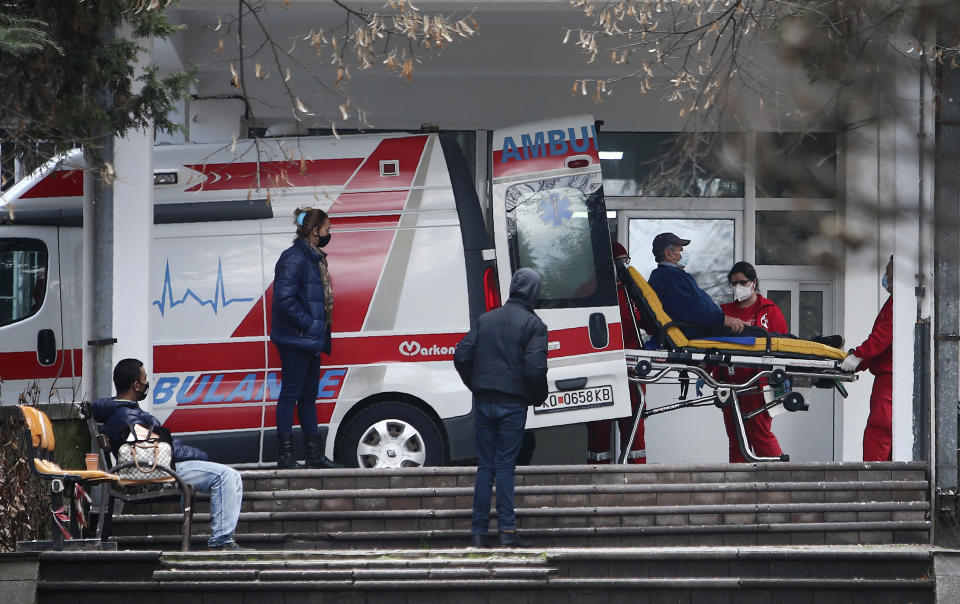 In this picture taken on Tuesday, Dec. 29, 2020, health workers wheel out a patient from an ambulance, at the entrance of the University Clinic complex in Skopje, North Macedonia. When thousands of people across the European Union simultaneously began rolling up their sleeves last month to get a coronavirus vaccination shot, one corner of the continent was left behind, feeling isolated and abandoned: the Balkans. (AP Photo/Boris Grdanoski)