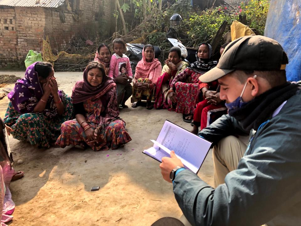 a man reading to children in nepal.