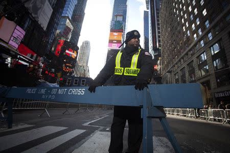 A security guard stands in Times Square as streets are closed in preparation for New Year's Eve celebrations in New York December 31, 2014. REUTERS/Carlo Allegri