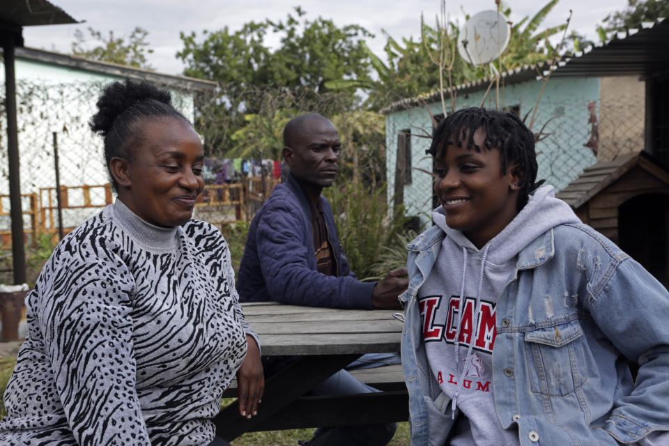 Andrew Ngwenya, center; his wife, De-egma, left, and their daughter sit outside their home in a working class township in Harare, the capital Zimbabwe, on Monday, July, 12, 2021. Ngwenya and his wife went to a hospital that sometimes had spare doses of COVID-19 vaccine, only to be turned away due to shortages. (AP Photo/Tsvangirayi Mukwazhi)