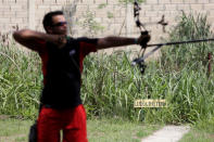 Venezuelan Olympic team archer Elias Malave aims his arrow during a training session in Maracay, in the state of Aragua, Venezuela June 6, 2016. The placard reads "Line of shooting". REUTERS/Marco Bello