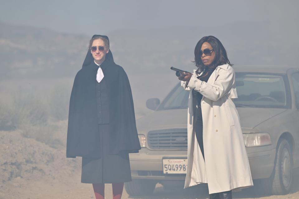 Nun Micaela Diamond (left) and Niecy Nash-Betts with a rifle in hand.