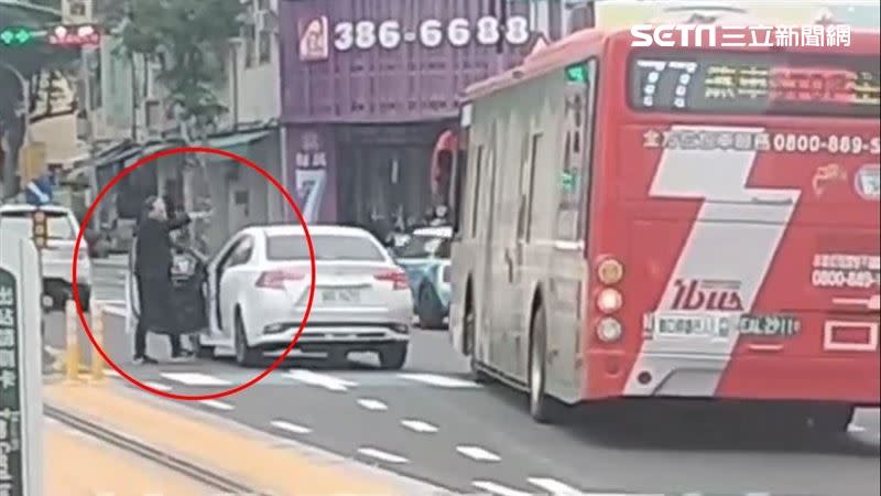 高雄市一名中年男子駕車行經三民區大順三路與鐵道一街口，和一輛公車發生行車糾紛，男子將車停在輕軌旁，對公車司機比手畫腳開罵，還一度折返回駕駛座掏出疑似板手工具揮舞。（圖／翻攝社會是新聞影音畫面）