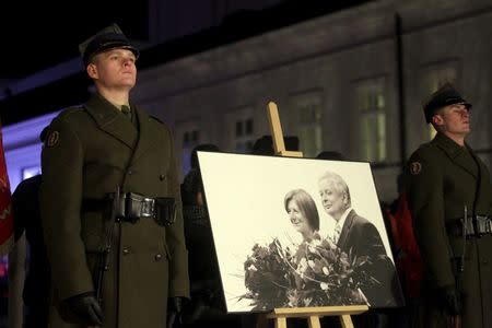 Poland's soldiers stand near a portrait of late Polish President Lech Kaczynski and wife Maria during a remembrance ceremony for the 2010 plane crash that killed Kaczynski and 95 others in Smolensk, in front of the Presidential Palace in Warsaw, Poland December 10, 2015. REUTERS/Przemek Wierzchowski/Agencja Gazeta