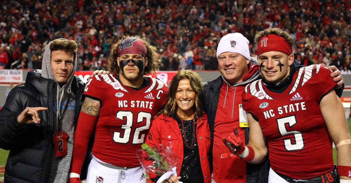 The Thomas family poses for a photo on the field at Carter-Finley Stadium on the campus of N.C. State University in Raleigh, N.C. Lex Thomas, left, is a senior quarterback for Heritage High School in Wake Forest, and has been recruited to play at N.C. State. Drake (32) and Thayer (5) play for the Wolfpack. Also in the photo are the players’ mother, Shelly, and father, Trevor.