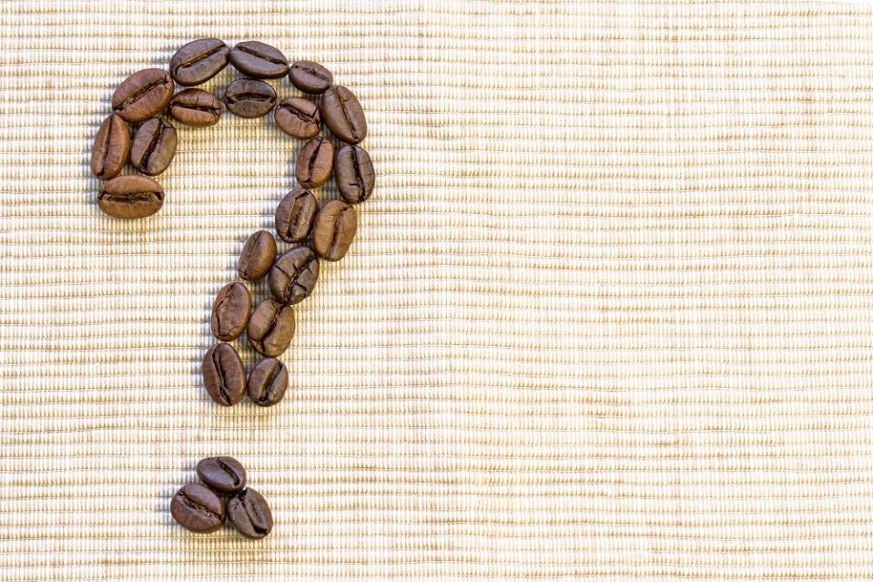 Coffee beans arranged in the shape of a question mark.