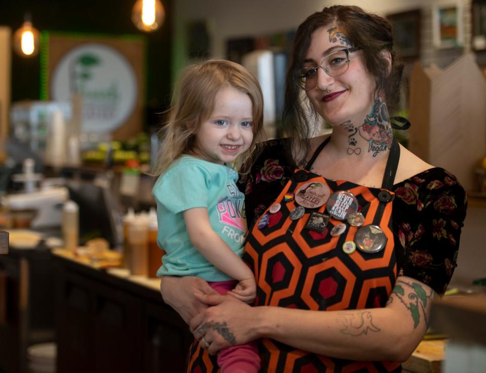 Brandie Scott holds daughter Aurelia Scott, 2, at Flourish Plant-Based Eatery in Evansville, Ind., Tuesday afternoon, March 15, 2022. Scott and husband Nick opened the restaurant for carry out only a few months after Aurelia was born in March of 2020 as the COVID-19 pandemic restrictions began. 