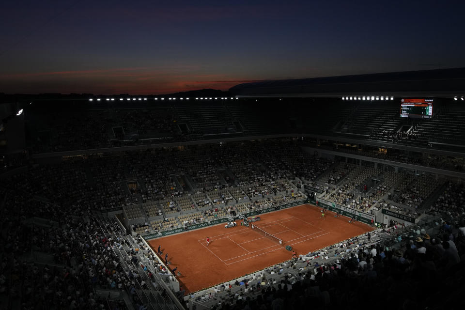 Spain's Rafael Nadal, right, plays Serbia's Novak Djokovic during their semifinal match of the French Open tennis tournament at the Roland Garros stadium Friday, June 11, 2021 at sunset in Paris. (AP Photo/Christophe Ena)