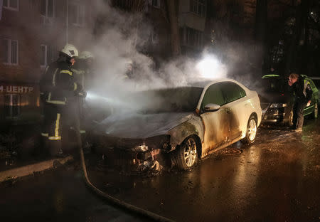 Firefighters extinguish a burning car of the embassy of Russia after a protest against the seizure by Russian special forces of three Ukrainian naval ships, which Russia blocked from passing through the Kerch Strait into the Sea of Azov in the Black Sea, in front of the Russian embassy in Kiev, Ukraine November 25, 2018. REUTERS/Serhii Nuzhnenko