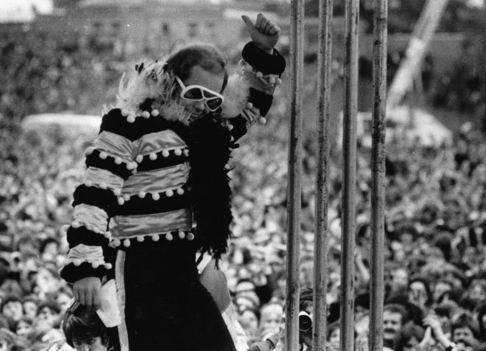 5th May 1974:  British pop singer and pianist Elton John on stage before a vast crowd at an open-air concert.  (Photo by Jack Kay/Express/Getty Images)