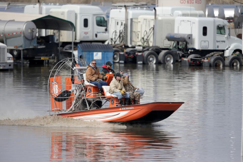 Gabe Schmidt, owner of Liquid Trucking, top right, travels by air boat with Glenn Wyles, top left, Mitch Snyder, bottom left, and Juan Jacobo, bottom right, as they survey damage from the flood waters of the Platte River, in Plattsmouth, Neb., Sunday, March 17, 2019.