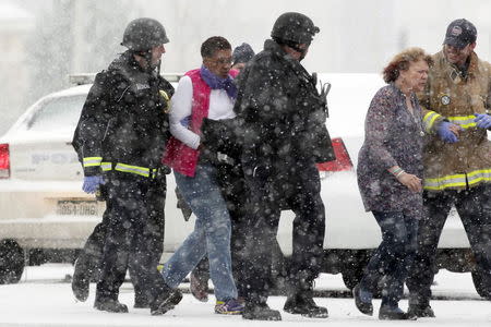 Two women are evacuated from a building where a shooter was suspected to be still holed up in Colorado Springs, Colorado, November 27, 2015, during a snowstorm. REUTERS/Rick Wilking