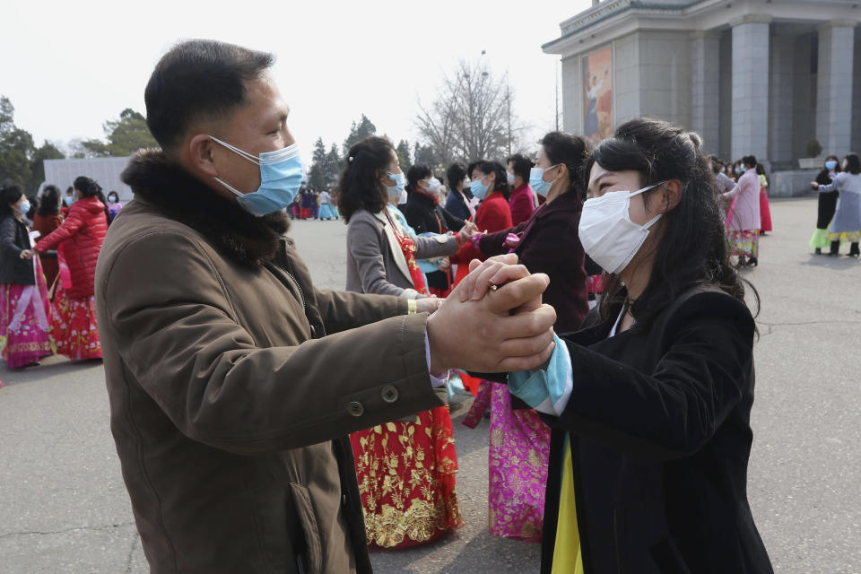 North Korean people dance as they celebrate International Women's Day in front of the Pyongyang Grand Threatre in Pyongyang, North Korea, Wednesday, March 8, 2023. (AP Photo/Jon Chol Jin)